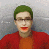 a woman with green hair and glasses is wearing a red sweater .