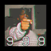 a man is smoking a cigarette in front of a computer screen and pointing at the camera .
