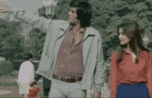 a man and a woman are walking through a park