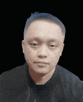 a close up of a man 's face with a black shirt on