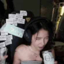 a woman wearing headphones is crying while holding a cup
