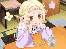 a girl with blonde hair is sitting at a table with a jar and a spoon in front of her