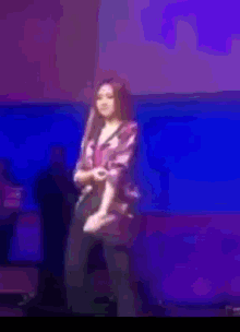 a woman giving a thumbs up while holding a microphone on stage