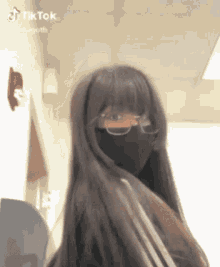 a girl with long hair wearing a mask and glasses