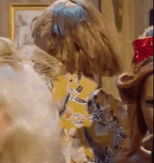 a group of women are standing next to each other in a room with a picture on the wall .