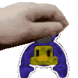 a hand is holding a sticker of a penguin with a yellow face on it .