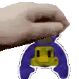 a hand is holding a sticker of a penguin with a yellow face on it .