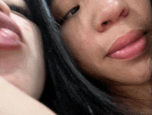 a close up of two women 's faces with their tongues out