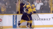 a hockey player is hugging another hockey player on the ice