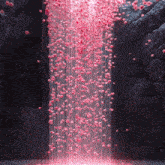 a waterfall with pink flowers falling down