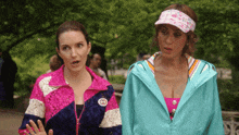 two women standing next to each other with one wearing a jacket with a gucci logo on it
