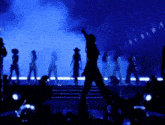 a group of people are standing on a stage in front of a blue background .