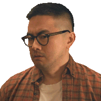 a man wearing glasses and a plaid shirt looks to his right