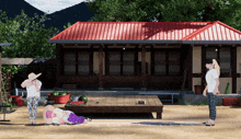 a woman in a hat stands in front of a house