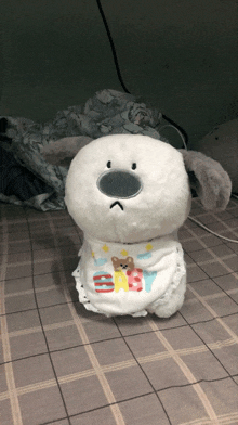 a stuffed animal with a bib that says ' baby ' on it