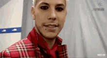 a close up of a man wearing a plaid shirt