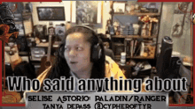 a woman wearing headphones is sitting in front of a screen that says who said anything about