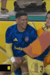 a soccer player wearing a blue jersey that says betsco on it