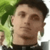 a close up of a young man 's face with a monster energy logo on his shirt .