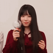 a woman in a red dress is holding a microphone in her hand .