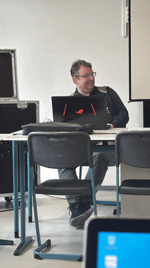 a man sits at a desk with a laptop on it
