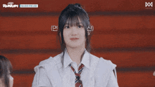a girl in a white shirt and tie applauds with a runup logo in the background