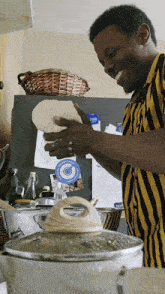 a man in a yellow and black striped shirt is holding a tortilla