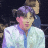a young man with purple hair is wearing a white shirt