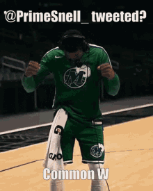 a basketball player wearing headphones and a green jersey with gatorade on the shorts