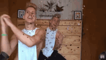 two young men are dancing in front of a sign that says vorostwip