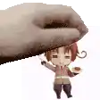 a hand is holding a small figurine of a boy on top of it .