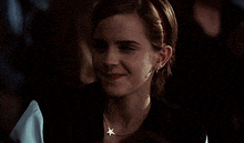 a woman wearing a necklace with a star on it is smiling