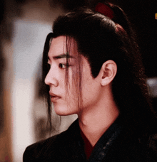 a close up of a man 's face with a ponytail