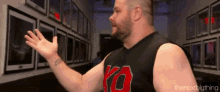 a man wearing a black tank top with ko on it