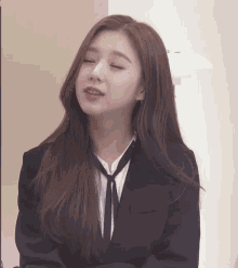 a woman in a suit and tie is making a face