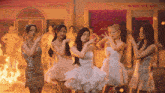 a group of women are dancing in front of a building that says nail & fair
