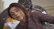 a woman is laying on a bed with her eyes closed and her hair in a braid .