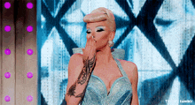 a woman with a tattoo on her arm is wearing a blue dress