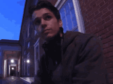 a man sitting in front of a building says yeah