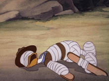 a cartoon character laying on the ground with bandages on his legs