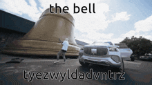 a man is standing in front of a large bell with the words the bell tyezwyldadvntrz