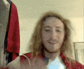 a man with long blonde hair and a beard is smiling