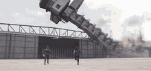 a man and a woman are running in front of a building that is being demolished .