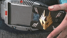 a person is holding a device that has the letter m on the front