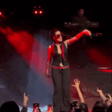 a woman is dancing on a stage in front of a crowd of people .