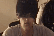 a person 's head is visible in a blurry photo with a white shirt on
