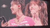 two girls are standing next to each other in front of a microphone .