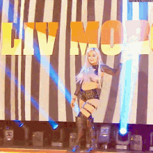 a woman stands on a stage in front of a sign that says liv moll