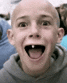 a young boy with a missing tooth is making a funny face with his tongue out