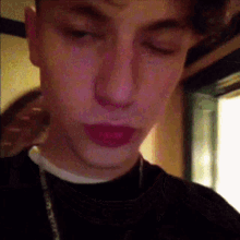 a close up of a young man 's face with red lips